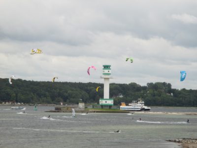 Kite surfers at the Friedrichsort lighthouse and SFK ferry in the Kiel Fjord